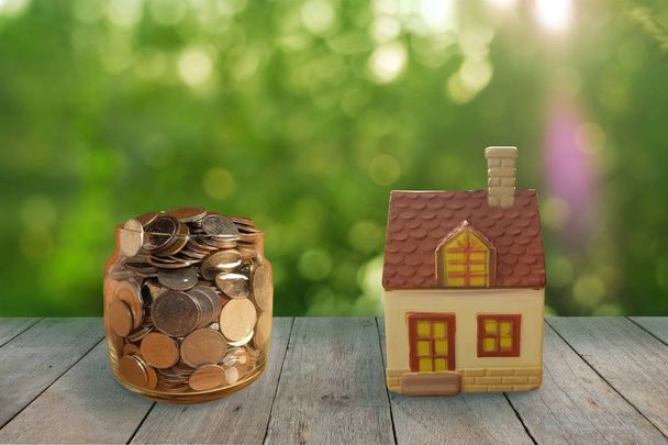 Saving money for home on Wooden floor with blurred green bokeh background. - Photo, Image