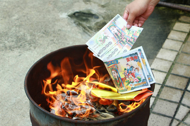Καίγοντας τα ασημένια και χρυσά πλαστά χρήματα χαρτί για Κινέζοι νεκρούς προγόνους. Joss χαρτί χρήματα κάψιμο μέταλλο bugket νεκρός στο κινεζικό νέο έτος. - Φωτογραφία, εικόνα