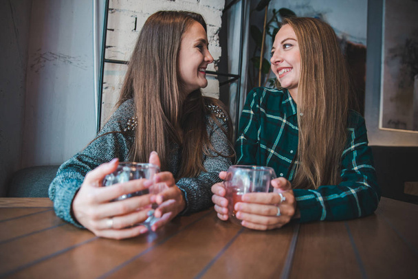 pari tyttöystäviä hauskaa istuu kahvilassa juo hedelmiä teetä käsite
 - Valokuva, kuva