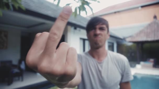 Retrato del hombre mostrando Fuck You al aire libre en frente de la casa
. - Imágenes, Vídeo