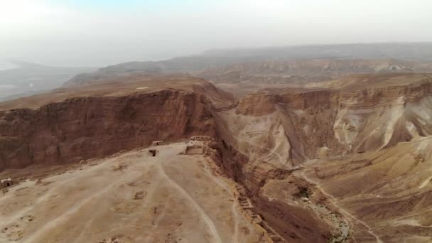 Masada erőd terület déli kerületi az izraeli Holt-tengeri térség déli District, Izrael. Ősi zsidó erőd a római birodalom, a júdeai-sivatagban egy szikla tetején. Elölnézet a levegőből. - Felvétel, videó