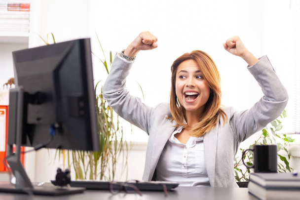 happy businesswoman in front of a computer in an office - Foto, Imagem