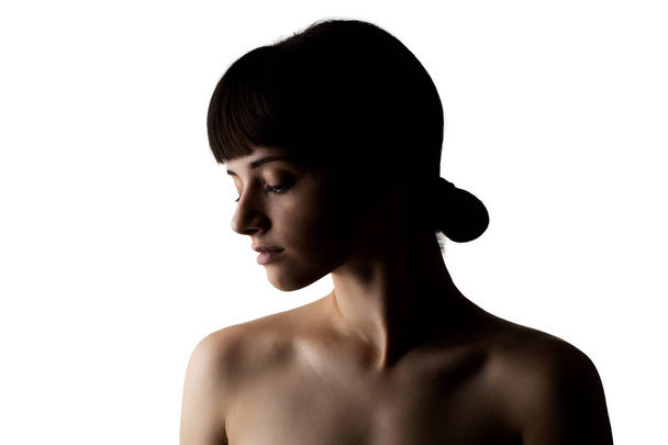 half silhouette portrait of a beautiful caucasian girl with her hair in a bu - Fotó, kép