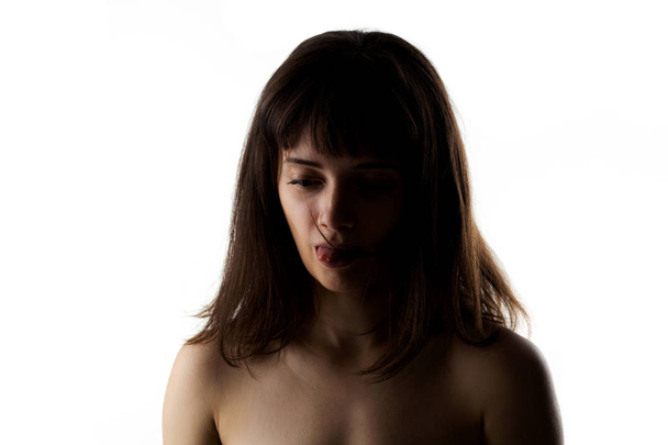 half silhouette portrait of a beautiful caucasian girl with her tongue out - Foto, immagini