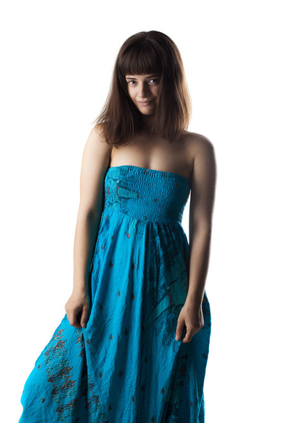 beautiful brunette girl standing in a blue casual dress, looking at camera - Zdjęcie, obraz
