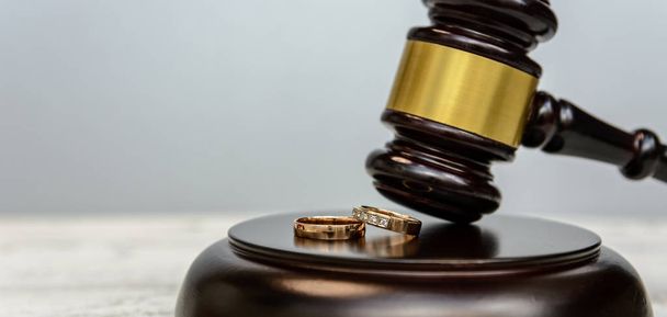 Law and Justice. Judge gavel and wedding rings on wooden background - Foto, Imagen