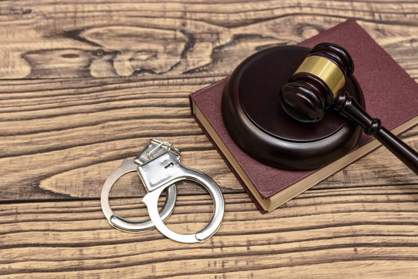 法と gustice。裁判官は、木製の背景に手錠のハンマー - 写真・画像