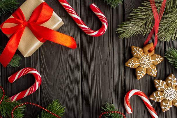 Composizione natalizia con pan di zenzero e regalo sullo sfondo in legno nero.Vista dall'alto.
. - Foto, immagini