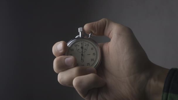 Close-up van één persoon een stopwatch op grijze achtergrond opstarten. 4k, 10 Bit, 4:2:2. - Video