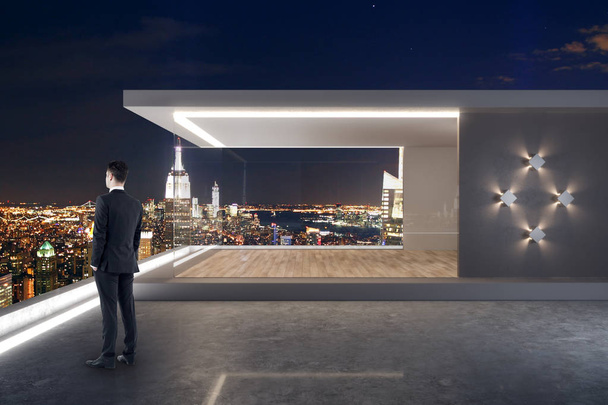 Молодой бизнесмен, стоящий на современной крыше с пентхаусом и ночным видом на Нью-Йорк
 - Фото, изображение
