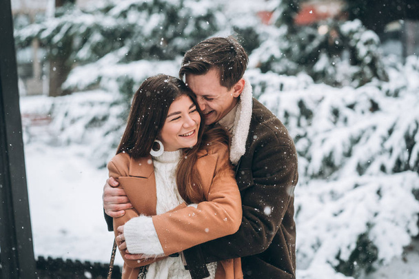 chico joven abraza a una hermosa chica en el parque nevado
 - Foto, imagen