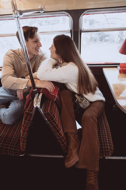 Amar a una joven pareja en invierno sentada en un café
 - Foto, Imagen