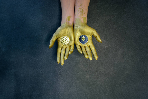 Women's hands painted with gold paint hold crypto currency - Foto, Imagem