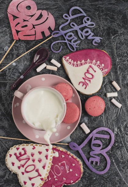 Romantica colazione di San Valentino. Biscotti a forma di cuore e una tazza di latte su un tavolo grigio. Vista dall'alto. Schizzi di latte
 - Foto, immagini