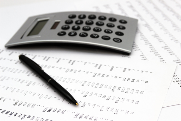 Financiële boekhouding, afbeelding een pluraliteit van getallen op papier en calculator, nummers op papier, een pen en een Calculator. - Foto, afbeelding