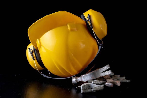 Workshop wrench and helmet on a black table. Accessories for workshop workers. Dark background. - Φωτογραφία, εικόνα