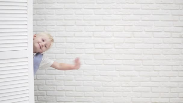 Sevimli yakışıklı çocuk beyaz bir perdenin arkasında saklanıyor - Video, Çekim