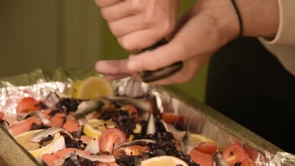 Close-up van handen van een meisje op de binnenlandse keuken is zouten of een gerecht in een prodvin van een handmatige molen peppering. Gezond thuis koken - Video