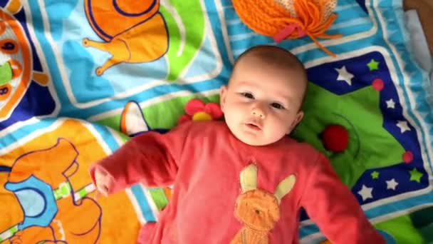 İki aylık bebek kız onu geri hareketli animasyon el hareketi üzerinde yalan. - Video, Çekim