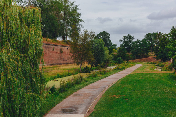 Pohled na cestu mezi stromy a zdí hradu, poblíž citadely Lille, Francie - Fotografie, Obrázek