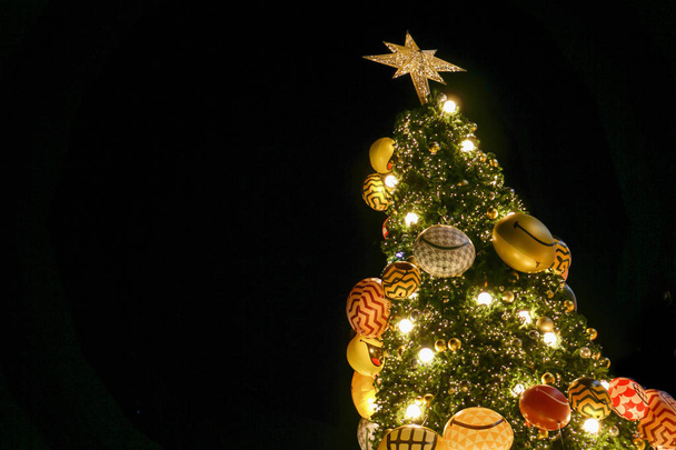 Κοιτάζω προς τα πάνω άποψη της χριστουγεννιάτικο δέντρο και να διακοσμήσετε με απομόνωμα του φωτισμού led σε μαύρο φόντο. - Φωτογραφία, εικόνα