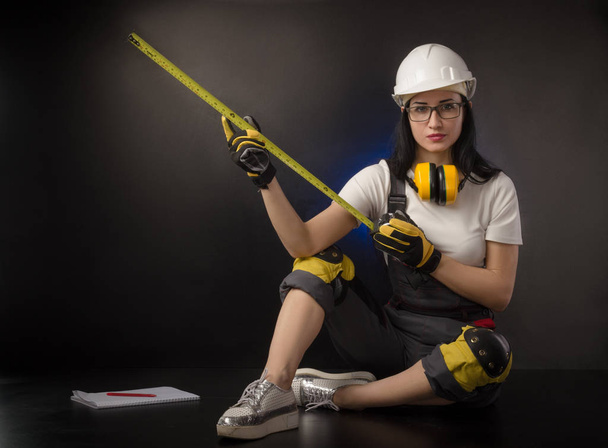 the girl in a construction firm works with a tape measure - Photo, Image
