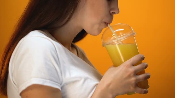 Молода жінка п'є апельсиновий сік і посміхається, здорове харчування напої, вітаміни
 - Кадри, відео