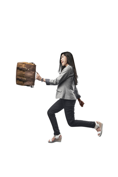 Attractive asian business woman walking with briefcase on her hands posing isolated over white background - Foto, immagini