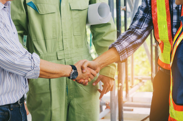 midsection of team of engineer and technician contractor shaking hands after finishing up business meeting to greeting start up project contract in construction site, partnership, teamwork concept - Photo, Image