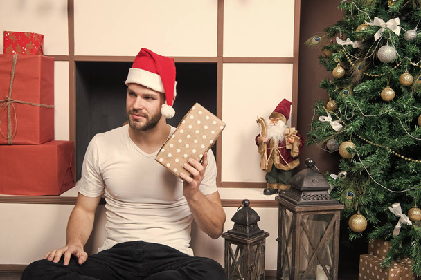 christmas macho in santa hat sit at fireplace - Photo, Image