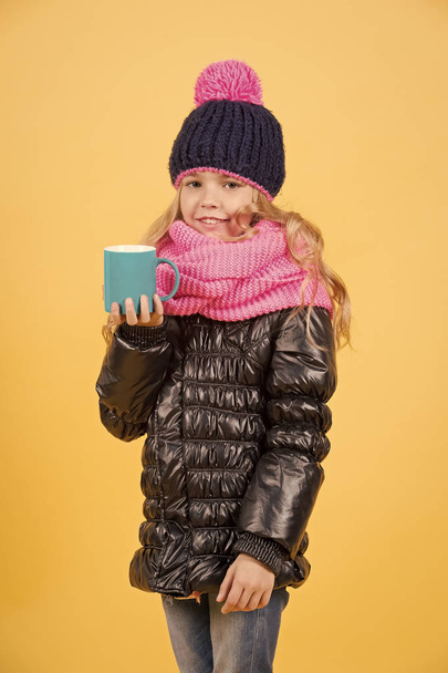 Kid girl in hat, scarf, jacket hold tea mug - Valokuva, kuva
