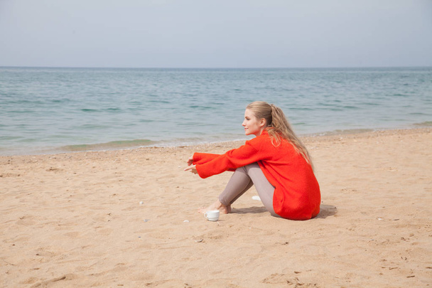 красива блондинка жінка червоним ходить на море піщаного пляжу - Фото, зображення
