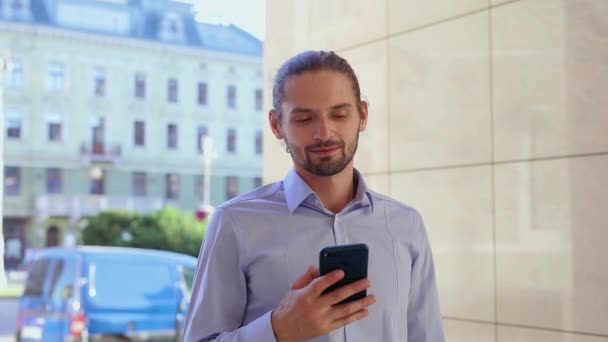 Homem usando telefone celular, mensagens na rua da cidade
 - Filmagem, Vídeo