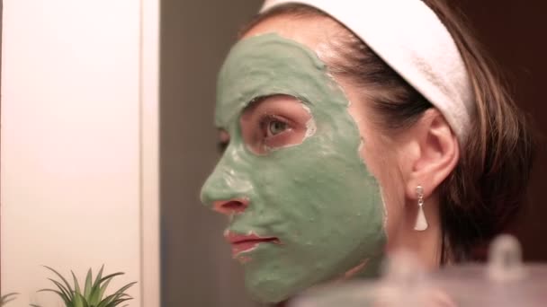 Beautiful woman with facial mask. Spa therapy for young woman receiving facial mask. - Footage, Video