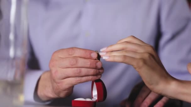 Proposta di matrimonio. Primo piano uomo che indossa anello di fidanzamento su Womans mano nel ristorante
 - Filmati, video