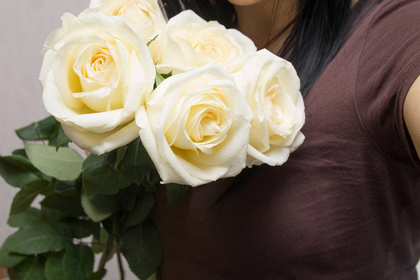romantic young woman holding bunch of gentle white roses as a gift on Valentine's Day - Foto, Bild