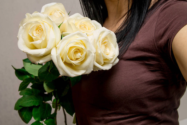 romantic young woman holding bunch of gentle white roses as a gift on Valentine's Day - Фото, изображение