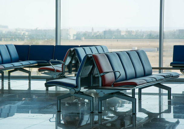 Пустой зал вылета в красно-синих цветах в аэропорту
 - Фото, изображение