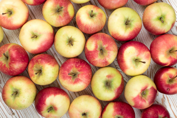 ganze rote und grüne weiche Apfelmuster bereit für Saft erzeugen Draufsicht. Bio-Äpfel auf rustikalem Holzgrund - Foto, Bild