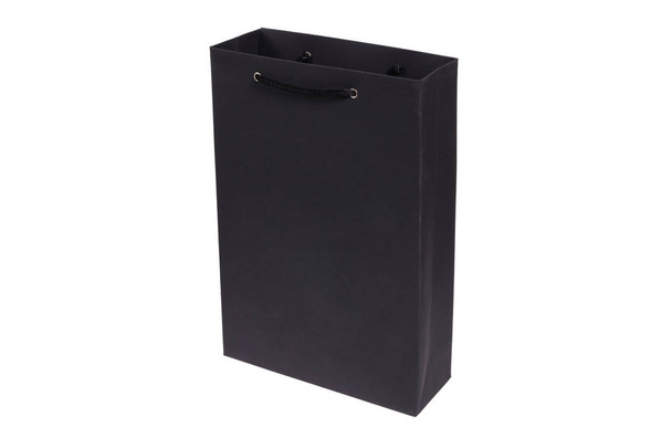 Closeup černý papír prázdný balíček s zpracovává izolované na bílém pozadí. Koncepce prodejny, nakupování, stylový lakonický balení prádla, alkohol, vánoční dárky, smuteční balíček - Fotografie, Obrázek