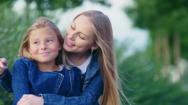 Smiling mother with daughter outdoors - Кадры, видео