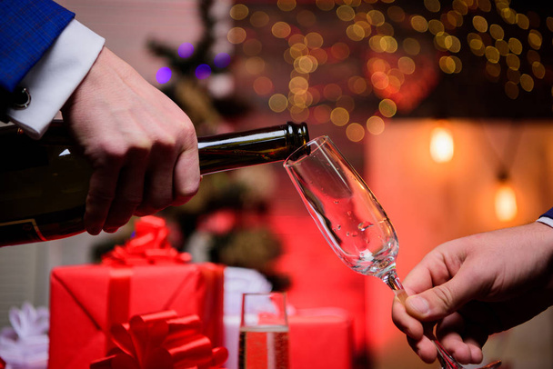 Hands pouring champagne into elegant glass christmas decorations background. Last minute before new year. Drink champagne or sparkling wine. Celebrate holiday with champagne. Happy new year - Foto, Imagem