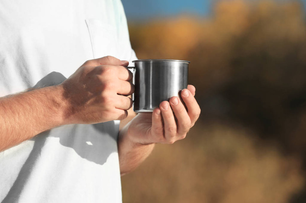 Male camper with metal mug outdoors, closeup. Space for text - Fotografie, Obrázek
