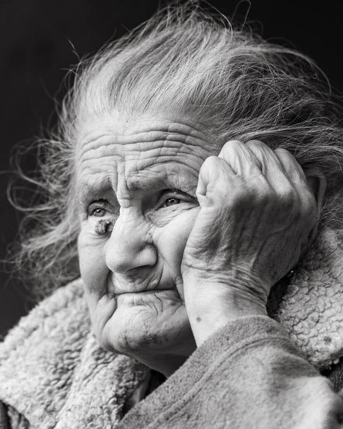 Concepto de vejez y estilo de vida. Retrato en blanco y negro de una mujer arrugada muy vieja y cansada al aire libre. Retrato de la cara de mujer muy vieja hoary primer plano. Proceso de envejecimiento - mujeres mayores muy ancianas
 - Foto, Imagen