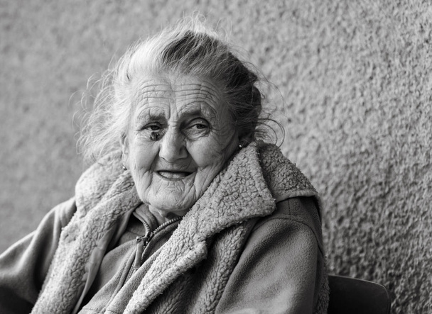 Öregségi és életmód fogalma. Fekete-fehér portré egy nagyon öreg és fáradt, ráncos nő szabadban. Nagyon régi Deres nő arca Vértes portré. Öregedési folyamat - nagyon régi vezető nők - Fotó, kép