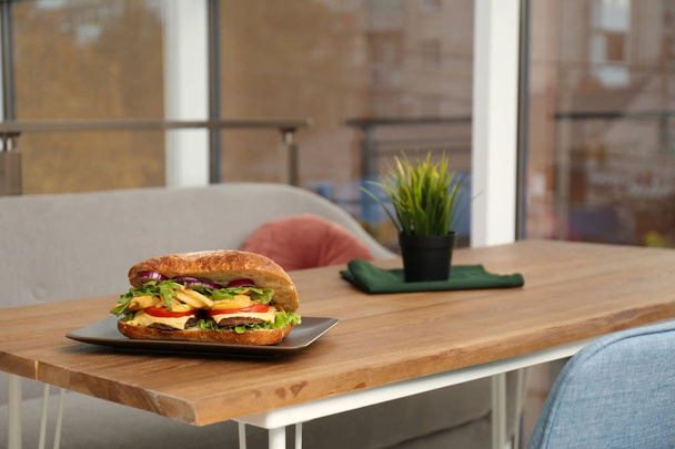 Plate with yummy sandwich on table in cafe - Fotoğraf, Görsel