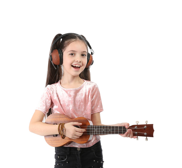 Portrait of little girl with headphones playing guitar isolated on white - Foto, imagen