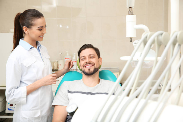Professional dentist working with patient in modern clinic - Foto, Bild