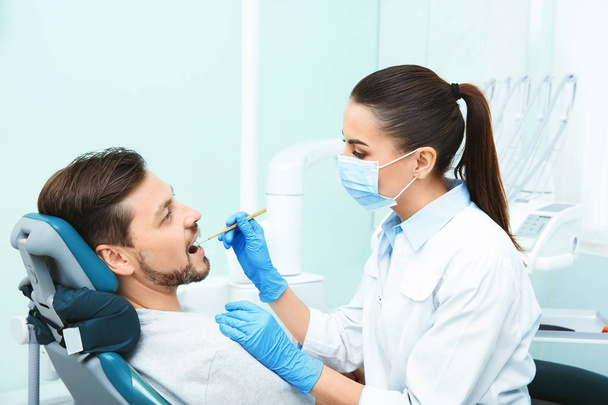 Професійний стоматолог, що працює з пацієнтом у сучасній клініці
 - Фото, зображення