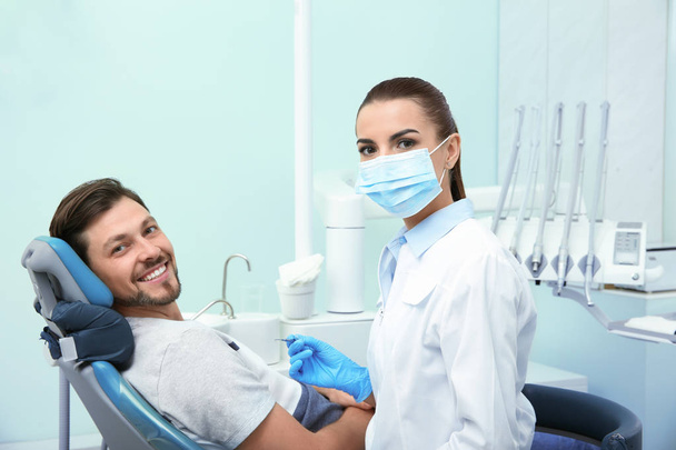 Dentista profissional e paciente feliz na clínica moderna
 - Foto, Imagem